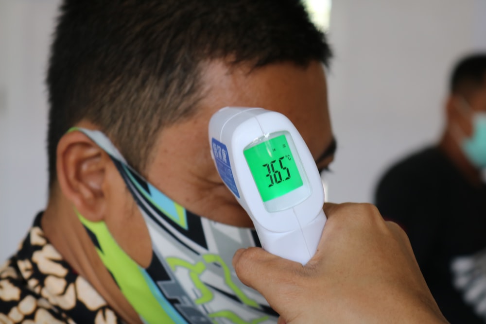 man in green white and blue shirt wearing white and blue digital watch