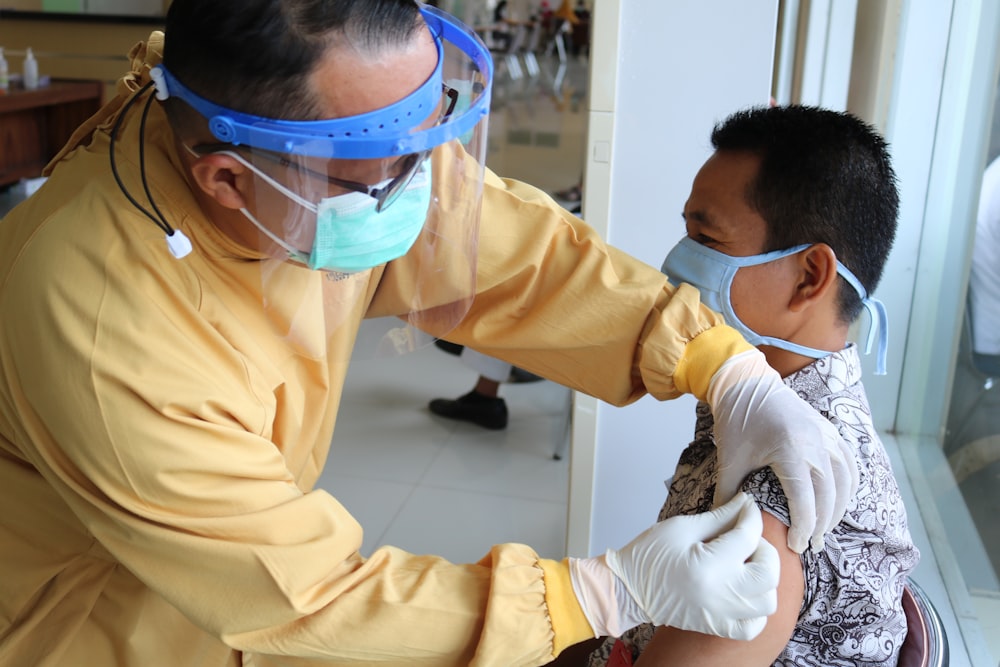 Mann im gelben Langarmhemd mit blauer Schutzbrille