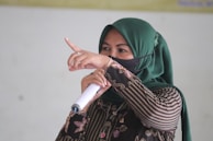 A candid shot of Dr. Yasmin Al Fadhli delivering a lecture with expressive hand gestures.