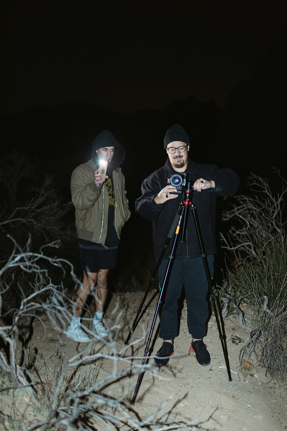 2 men in black and yellow jacket holding a black and gray fishing rod