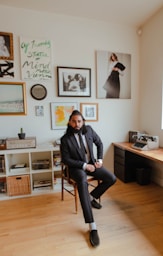 man in black jacket sitting on chair