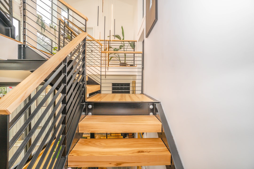brown wooden staircase with stainless steel railings