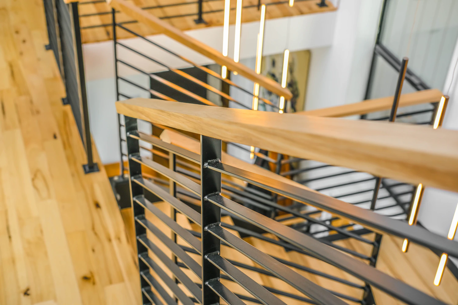 Close view of mixed wood and black metal railing details in a modern staircase