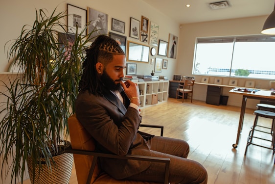 A cinematic shot of a focused businessman in a tailored navy suit reviewing contracts in a sleek modern office.