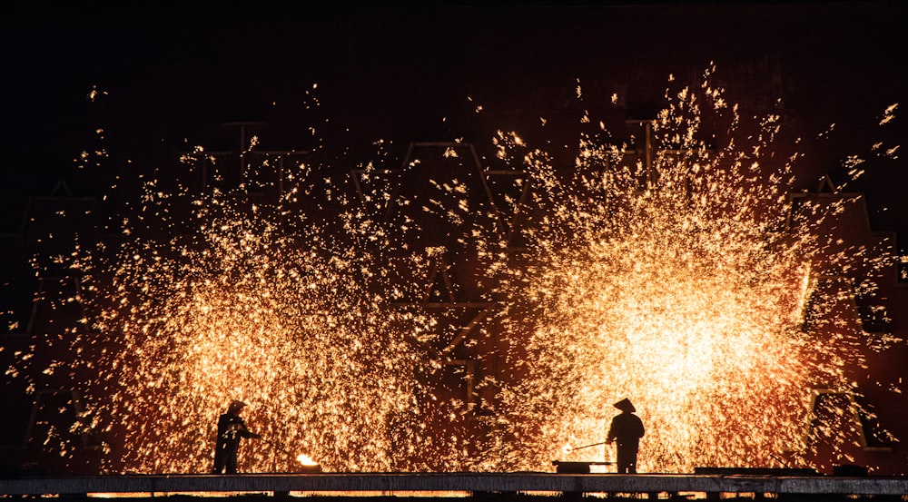 people watching fireworks display during night time