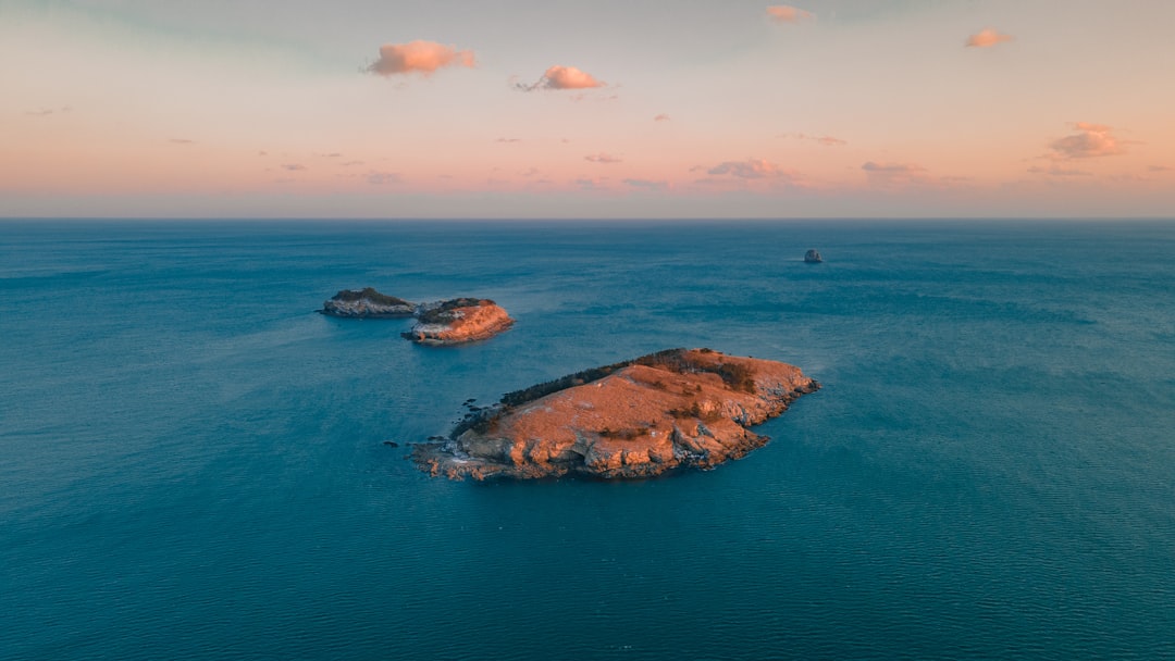 brown rock formation on blue sea under blue sky during daytime