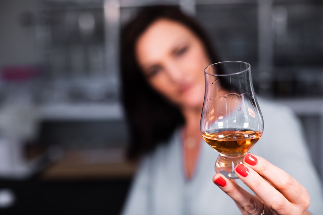 woman holding clear wine glass