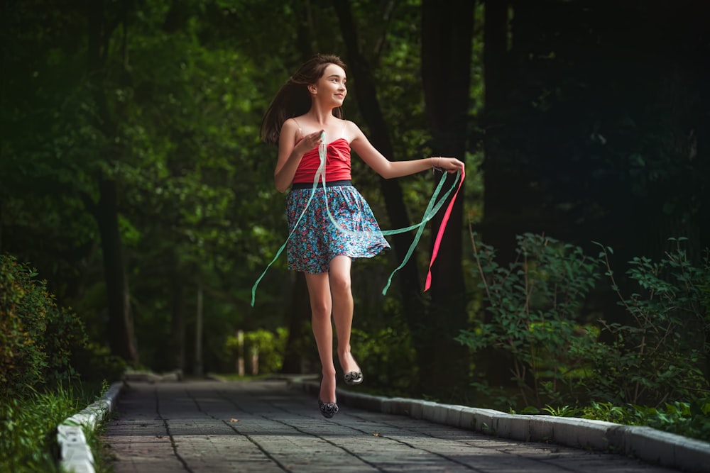 woman in red and white stripe dress standing on gray concrete pathway