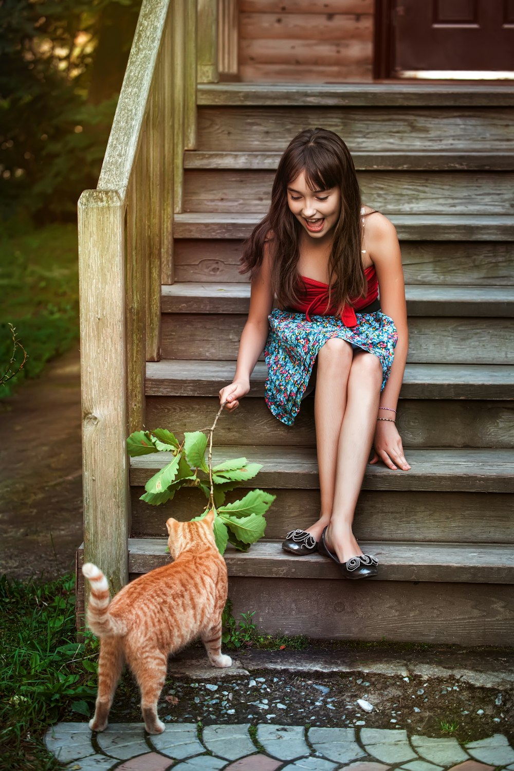 woman in blue and white floral dress sitting on brown wooden stairs