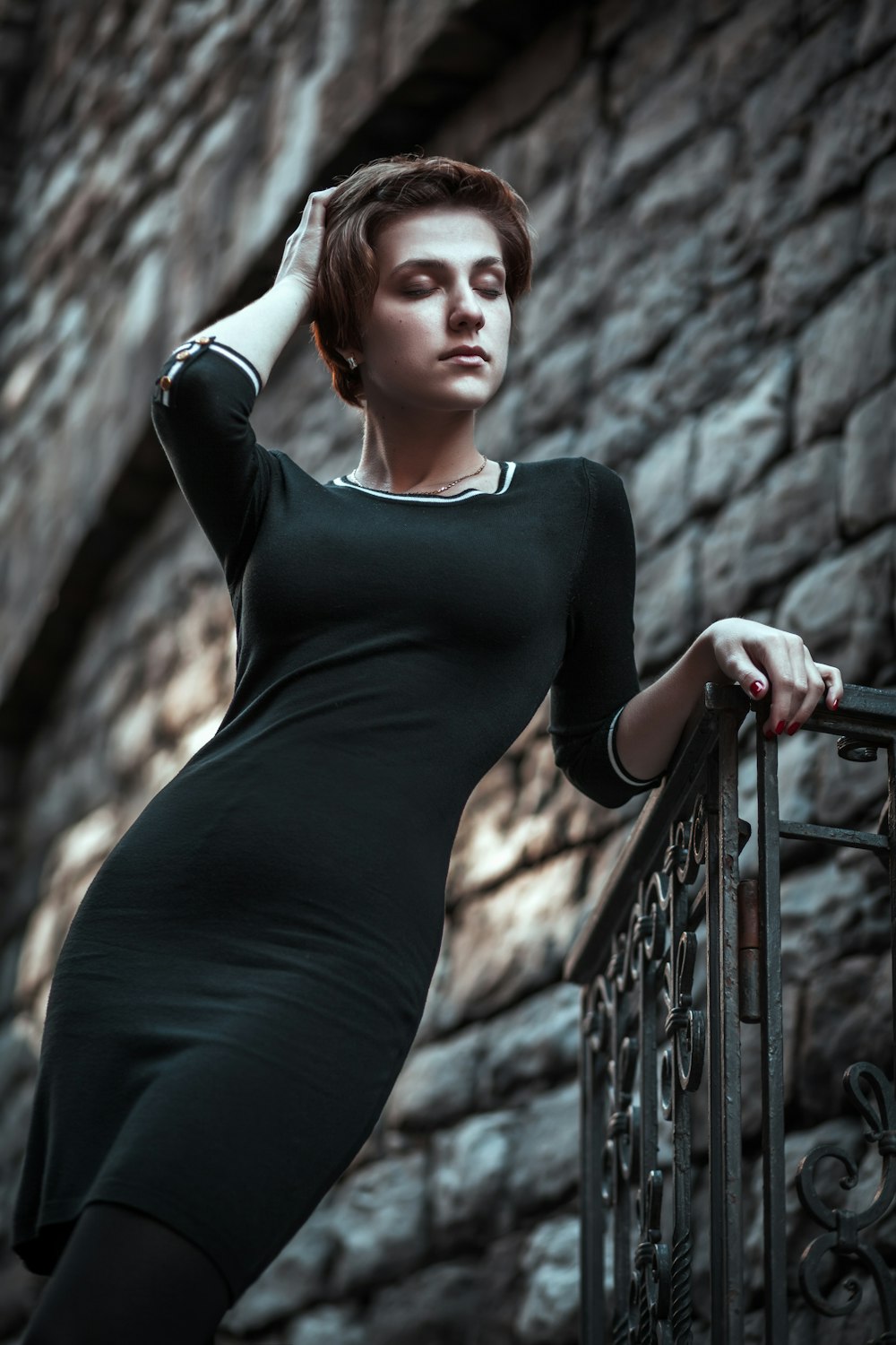 Femme en robe noire à manches longues debout sur des balustrades en métal noir