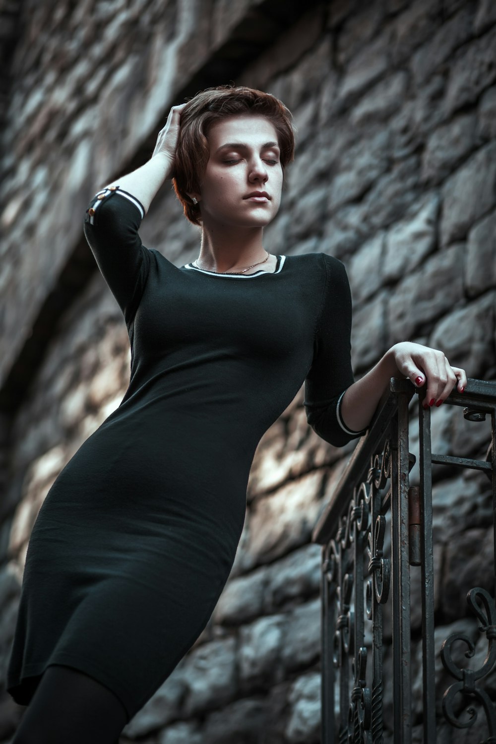 woman in black long sleeve dress standing on black metal railings