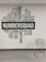 A wall of typography art featuring motivational words and phrases such as 'Skills', 'Training', 'Leadership', and 'Team'. The word 'NUMBERSQUAD' is prominently displayed in the center. Adjacent to the wall is a tall stool with a wooden seat and metal legs on a light, laminate floor.