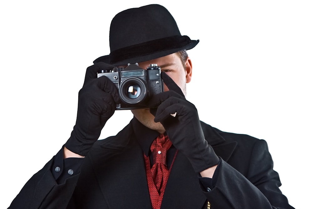 man in black blazer holding black camera