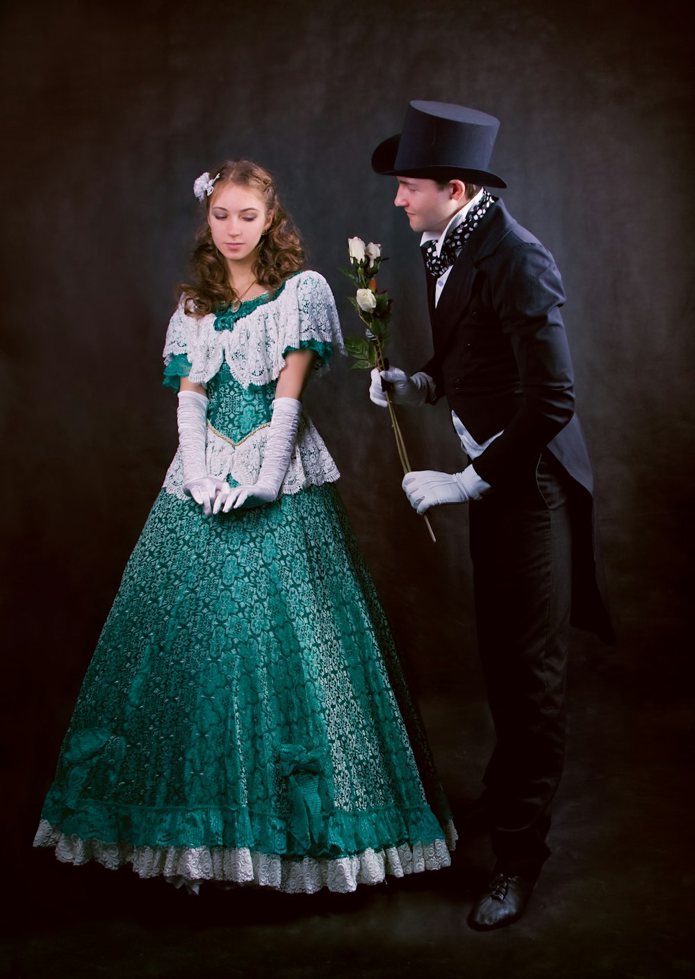 man in black suit jacket beside woman in green dress