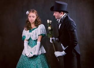 man in black suit jacket beside woman in green dress