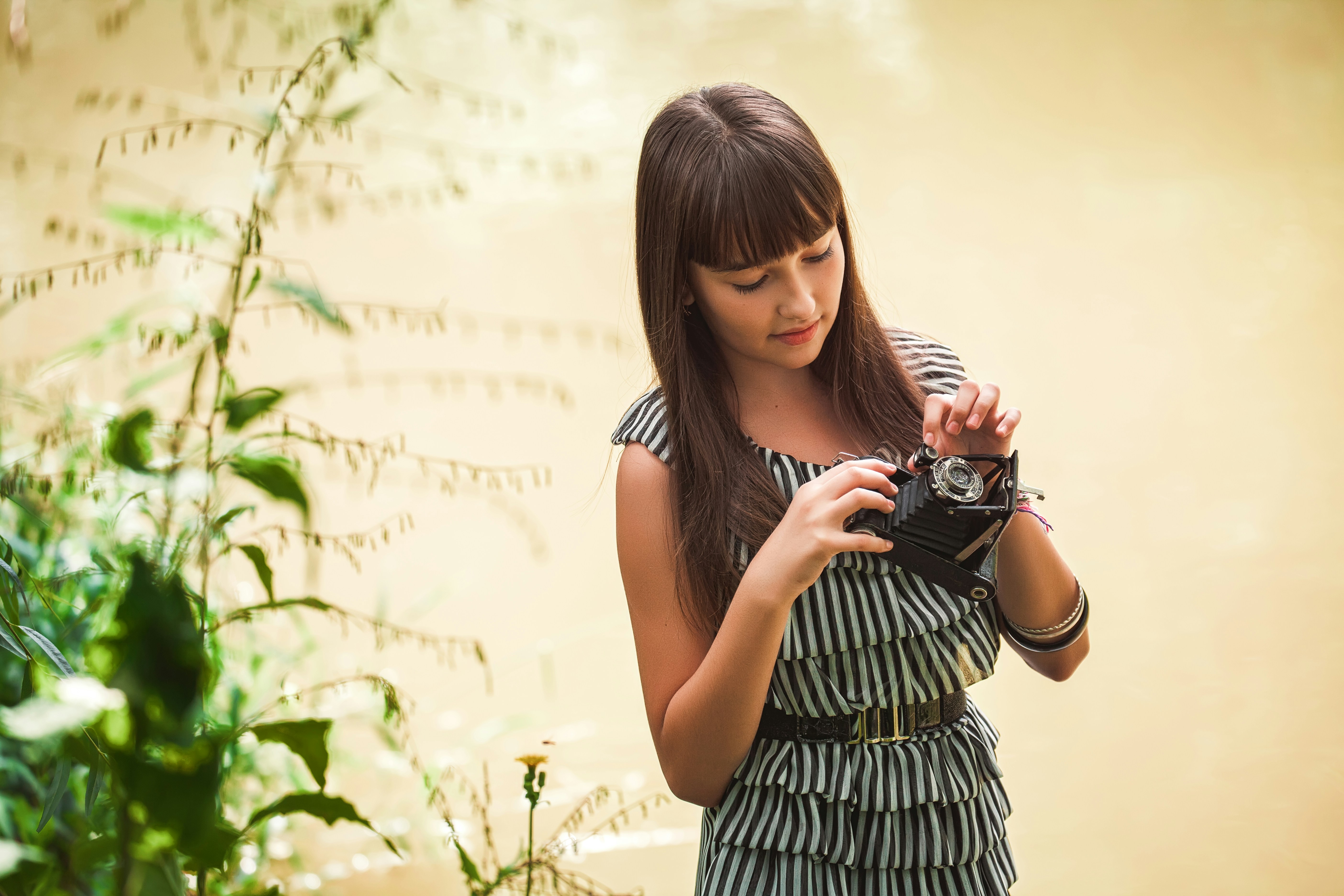 woman in black and white stripe tank dress holding black dslr camera