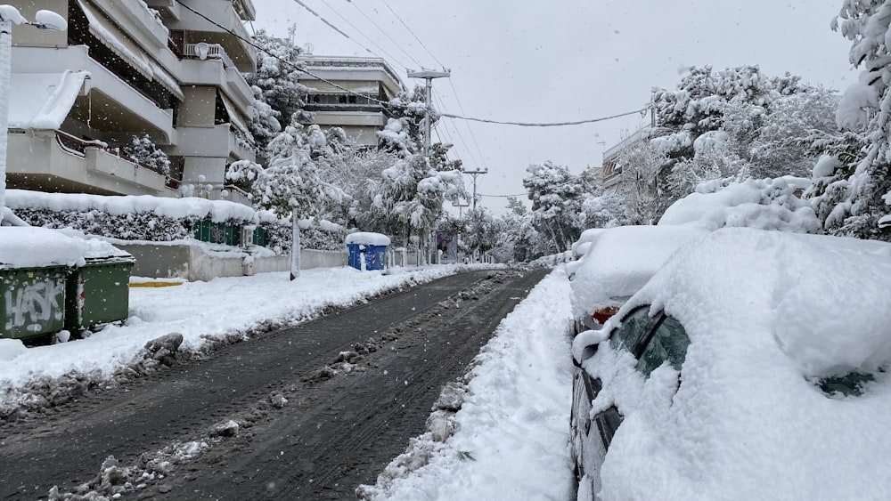 Cubos de basura blancos y azules en suelo cubierto de nieve