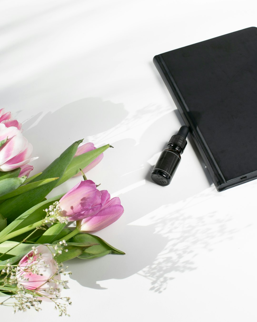 black book on white and pink floral textile