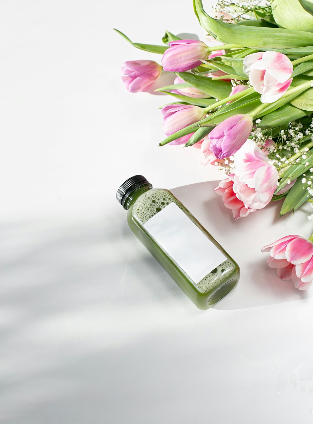 pink and white flowers on clear glass bottle