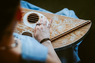 A customer gently winding a music box, smiling as soft melodies begin to play.