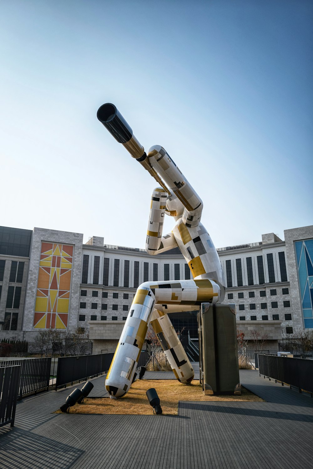 white and black telescope near white concrete building during daytime