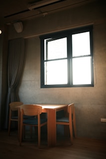 A sleek wooden dining table with minimalist design, bathed in natural light.