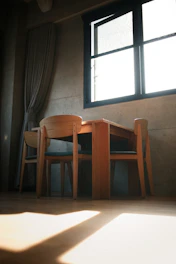 brown wooden chairs beside window