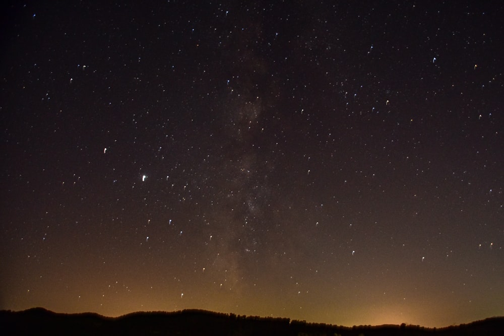 silhouette of mountain under starry night