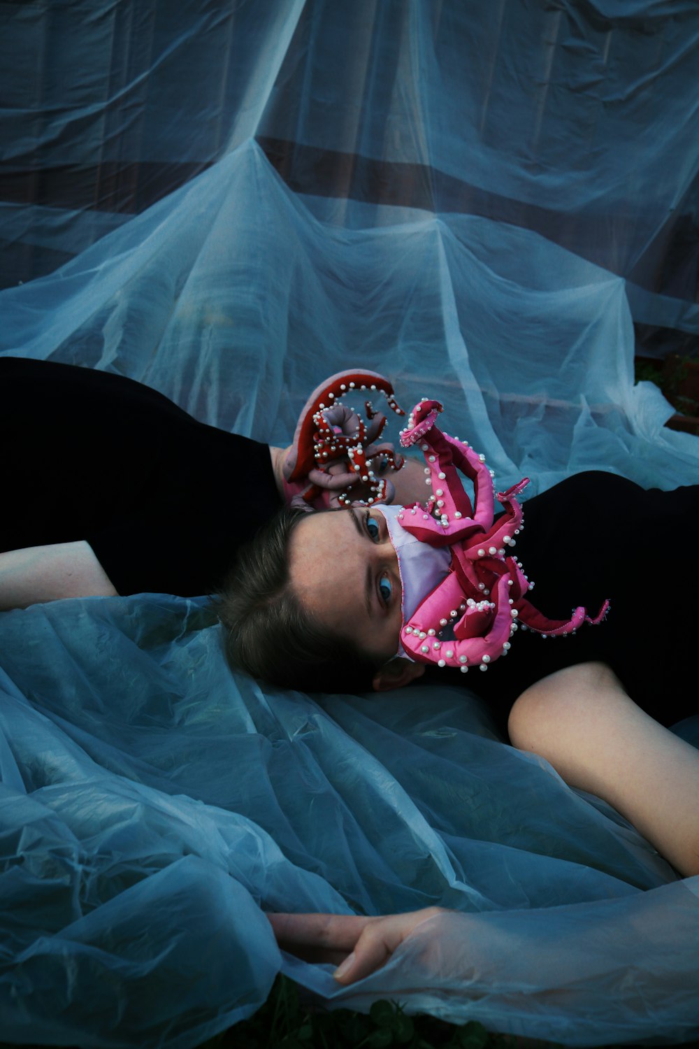 girl in pink dress lying on white textile