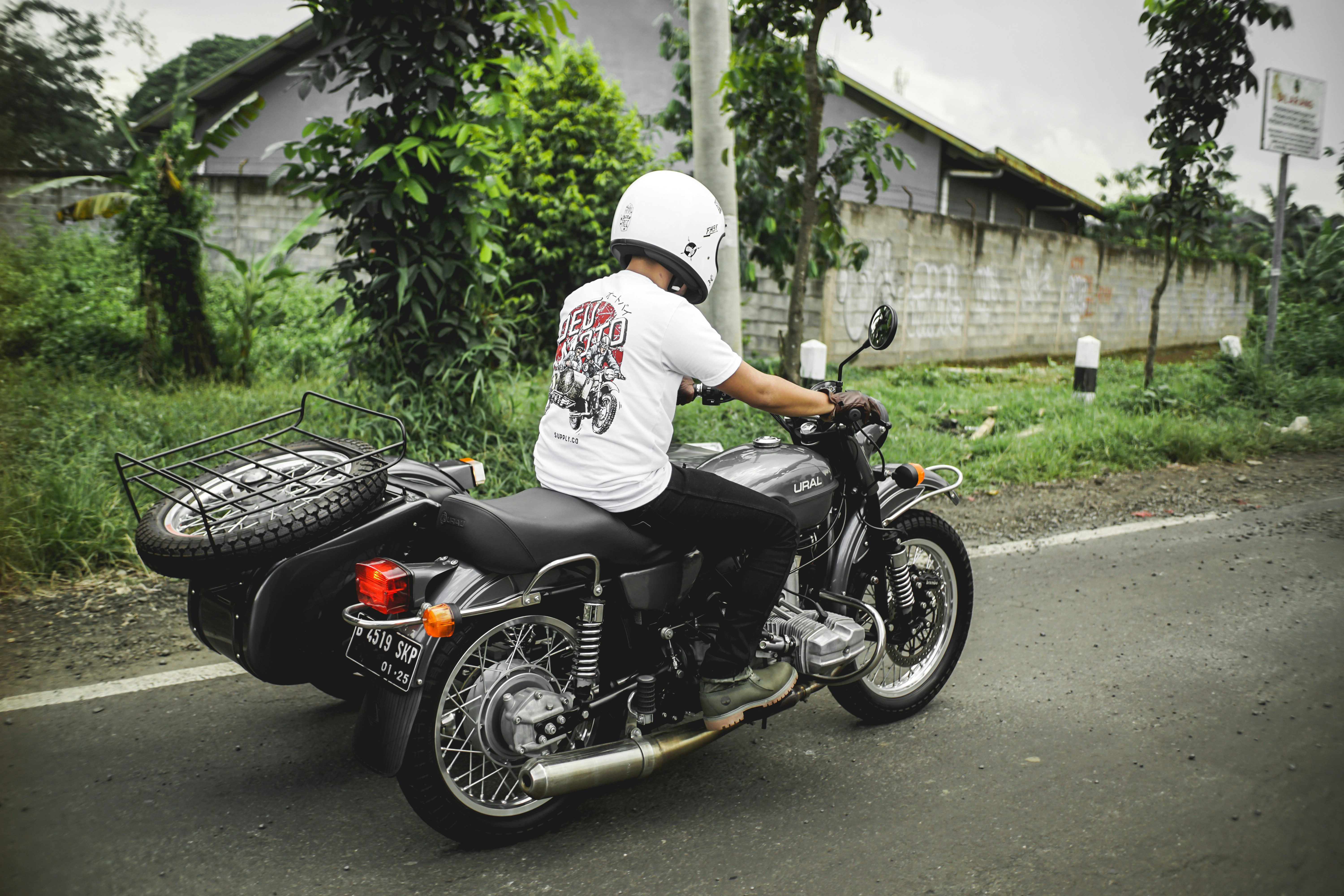 man in white shirt riding black motorcycle
