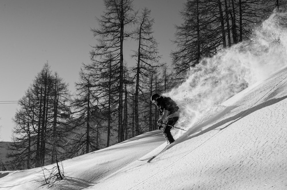 man in black jacket and pants riding ski blades on snow covered ground