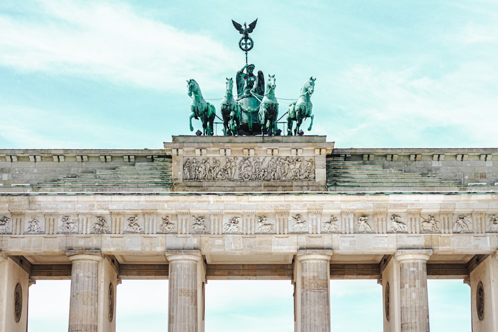 man riding horse statue under white clouds during daytime