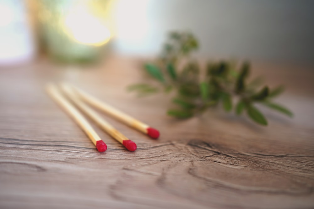 red and green cotton buds on brown wooden table