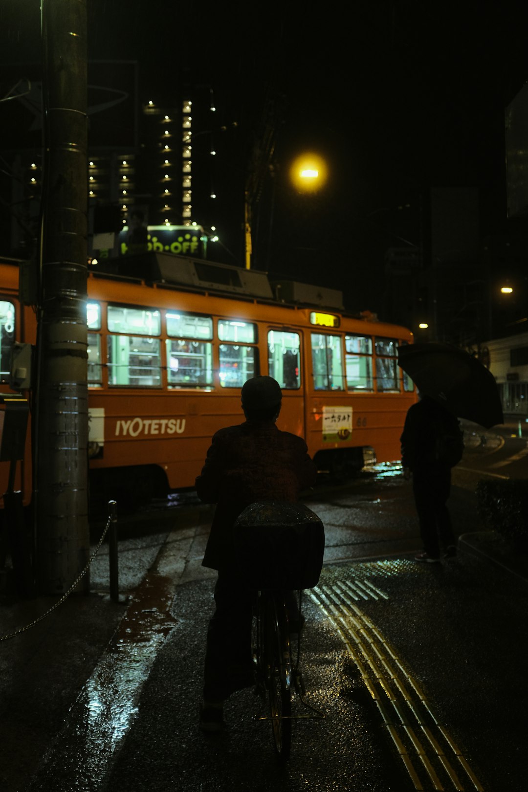 person in black jacket walking on sidewalk during night time