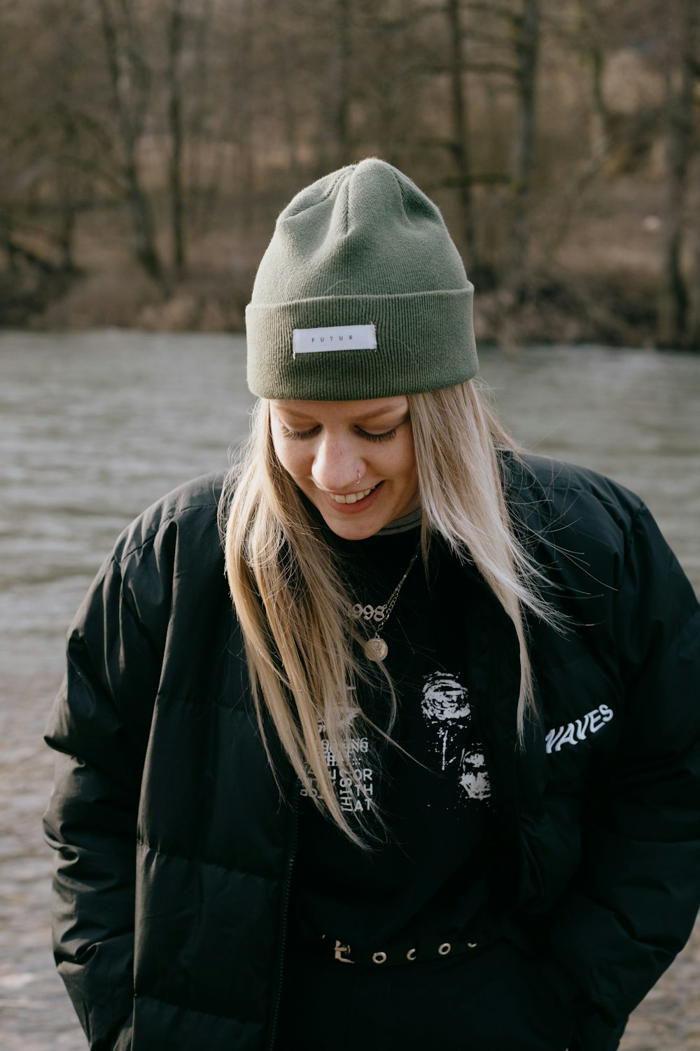 Femme en veste noire portant une casquette grise en tricot