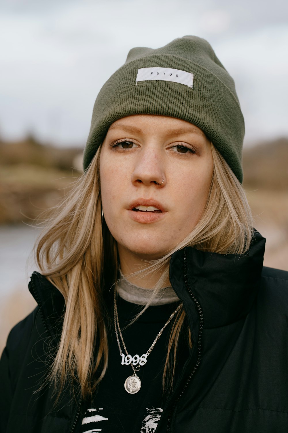 woman in black jacket wearing green cap