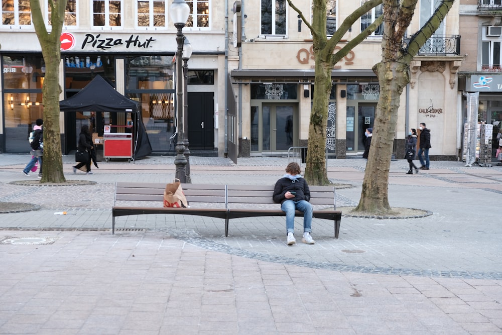 couple sitting on bench near building during daytime