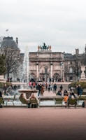 people sitting on bench near fountain during daytime