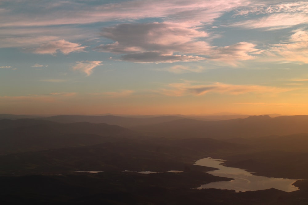 aerial view of mountains under cloudy sky during daytime