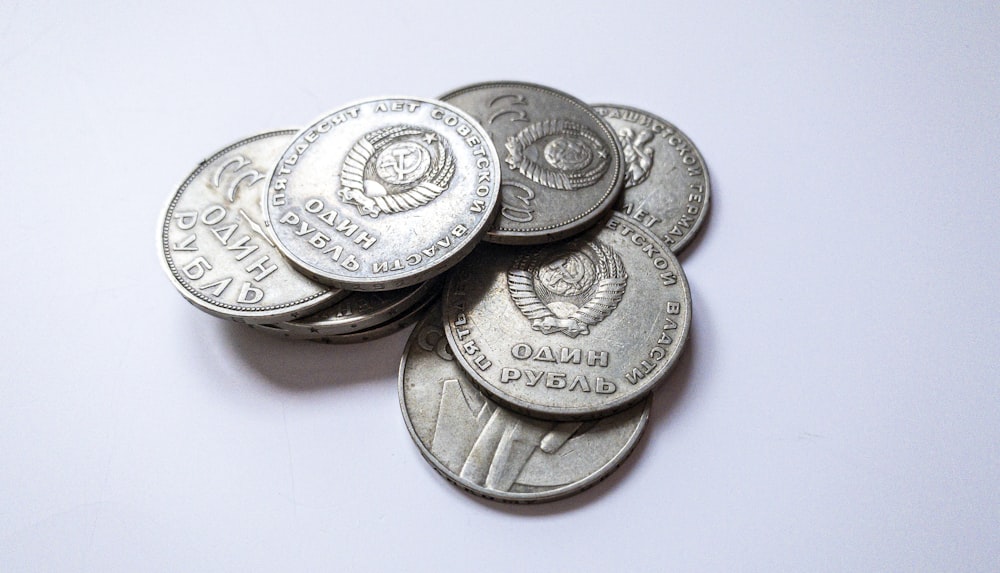 silver and gold coins on white surface