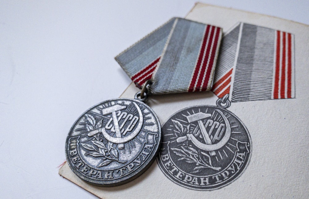 silver round coin on white textile