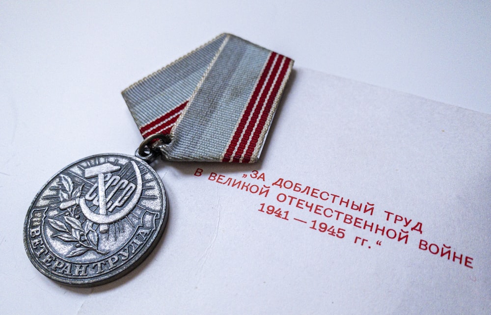 silver round coin on white paper