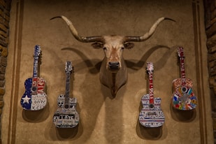brown deer figurine beside white and black electric guitar