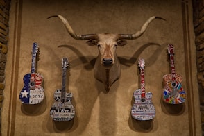 brown deer figurine beside white and black electric guitar
