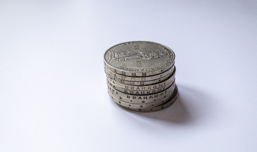 silver round coin on white table