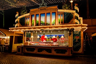 An inviting mobile food stall decorated with bright banners and lights in an outdoor market.