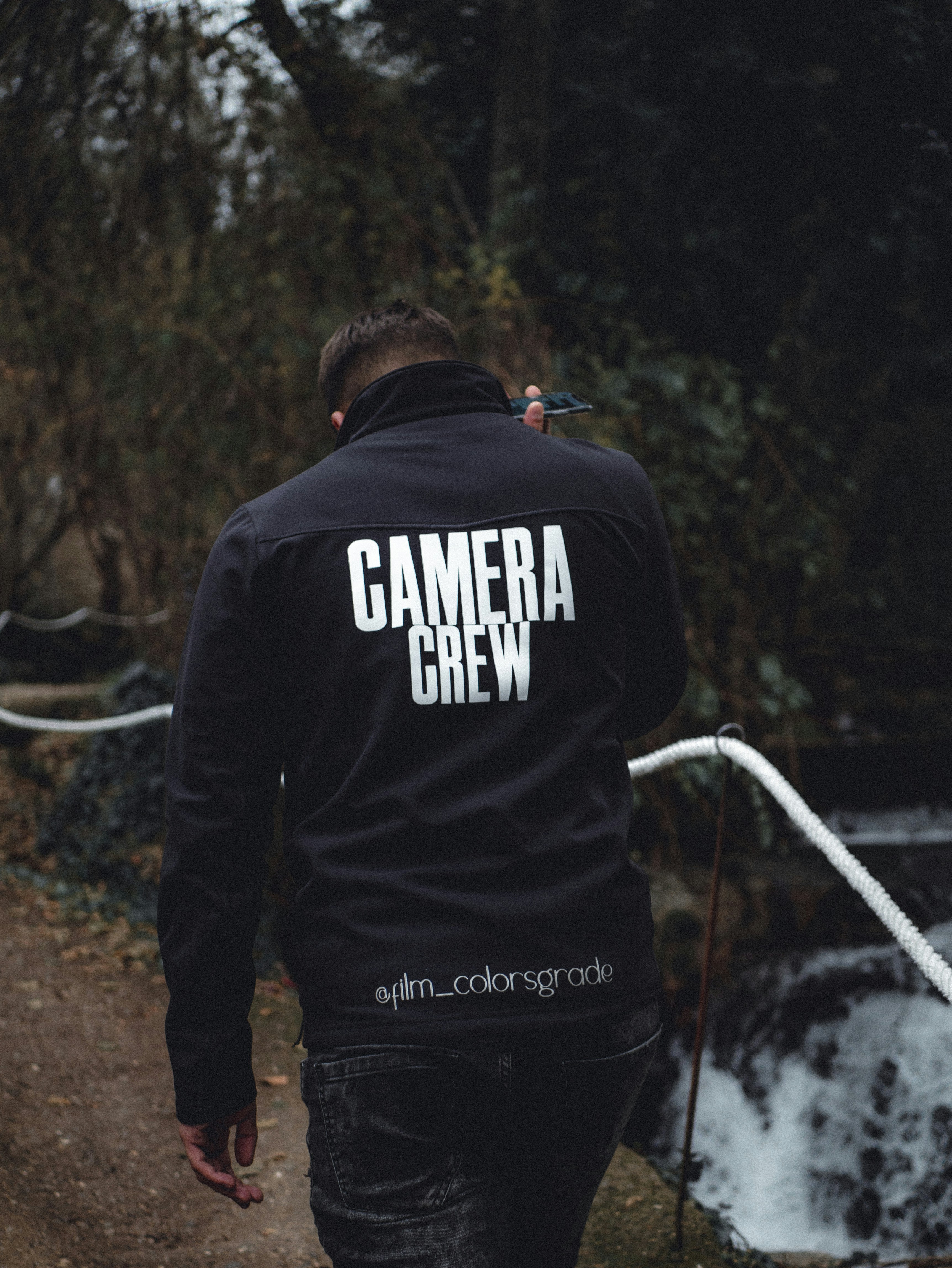 homem de moletom preto e branco e calças pretas em pé no solo marrom