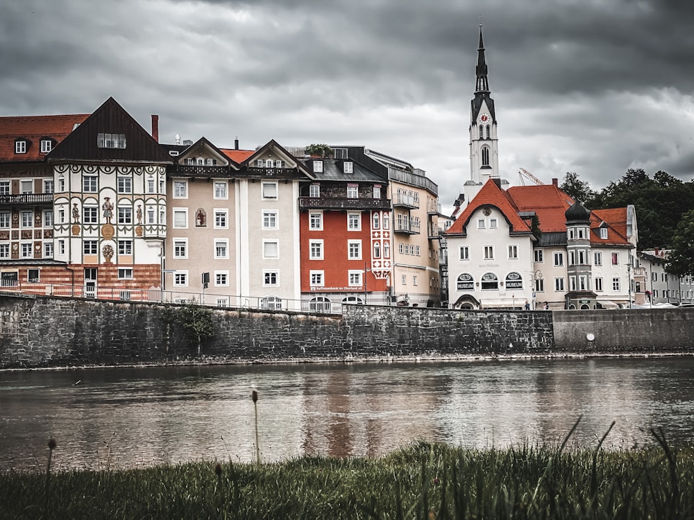 red white and black concrete building beside river during daytime