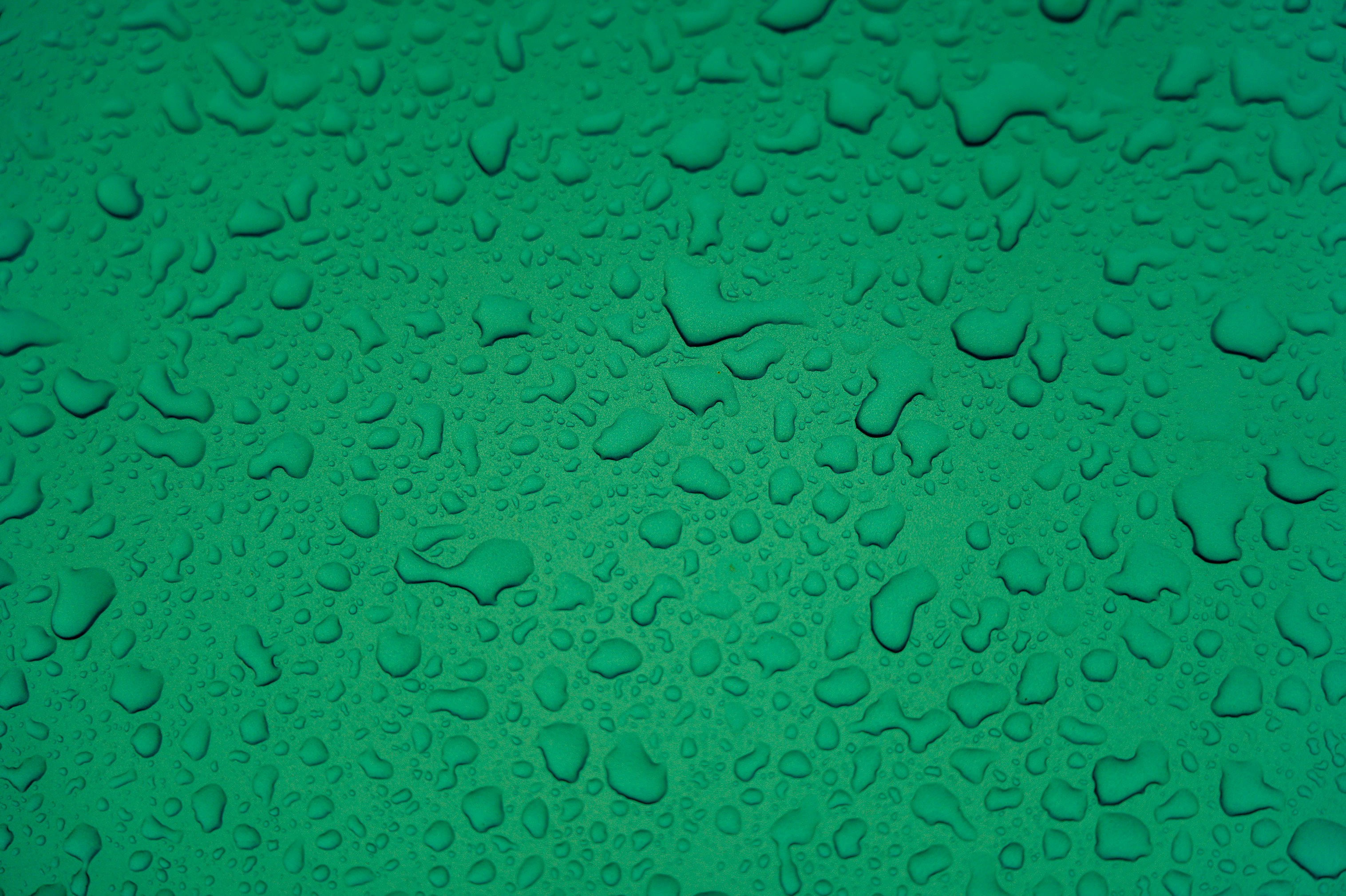 Raindrops on a green metal surface