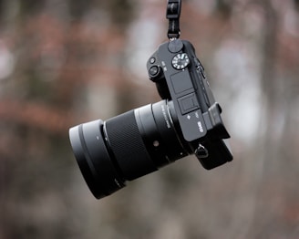 black dslr camera on brown wooden table